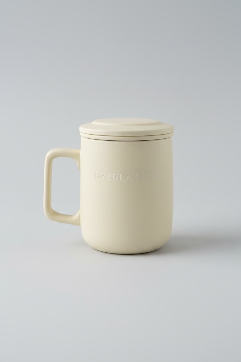 Beige Everlastea mug with lid on a white surface