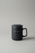 Black mug with 'EVERLASTEA' branding on a white surface.