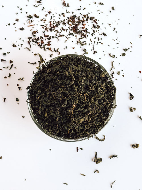 Organic Jasmine Gold Dragon Loose leaf Green Tea in clear bowl with white background.