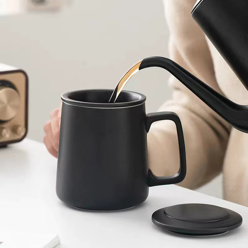 Black mug being filled with tea from a black teapot on a white surface.
