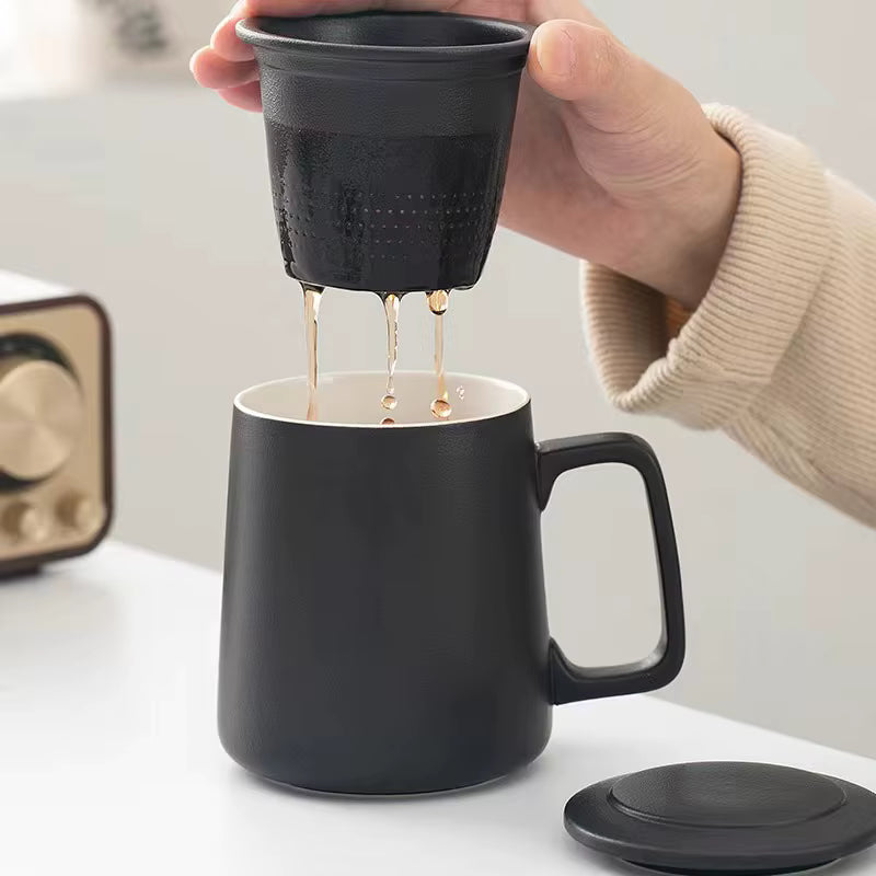 Person pouring coffee from a black portable coffee maker into a black mug.