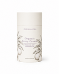 A cylindrical white container of Everlastea Organic Ivory Cream, featuring elegant black botanical illustrations of tea leaves and pods on the label.