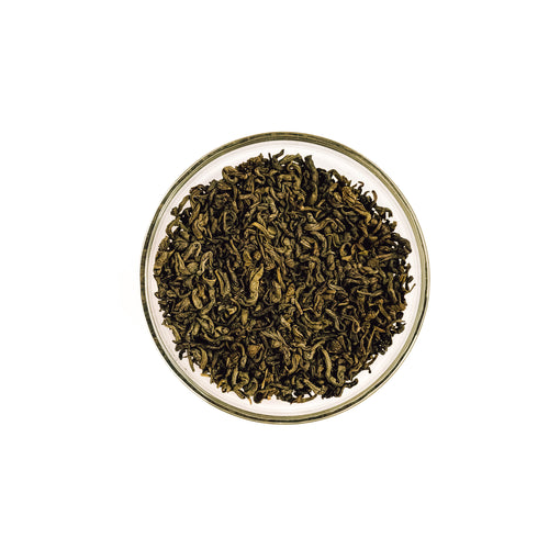 Dry organic jasmine gold dragon green tea leaves in a glass bowl on a white background